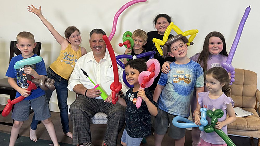 Scott Pevehouse teaching children with balloons at a church association meeting in California.