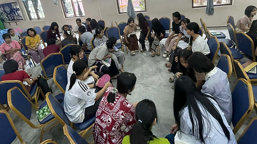 Children and teenagers seated in a circle at a summer church camp in Myanmar.